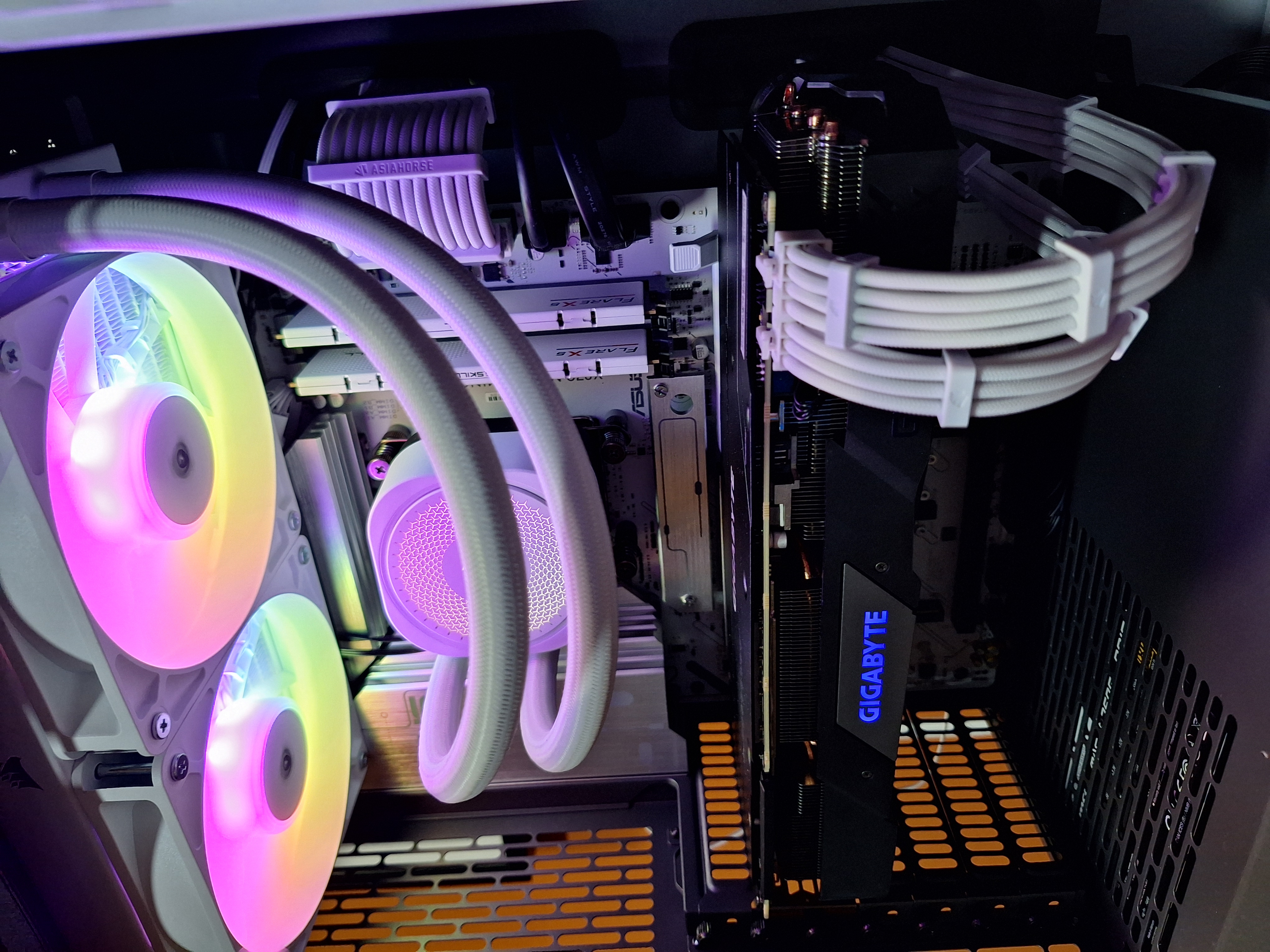 Close-up of the illuminated liquid cooler, memory, graphics card, and white cable extensions